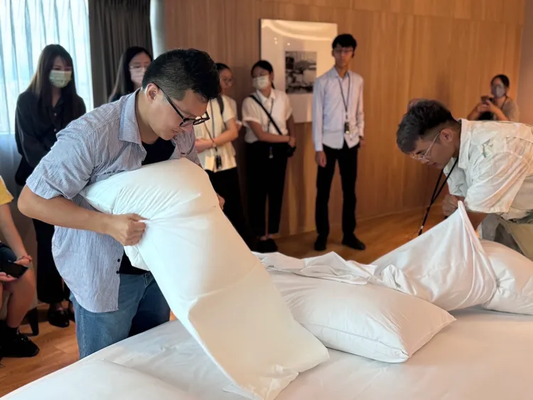 青年學員體驗房務整理基本技能更換枕頭套及清潔環境的小撇步。青年局提供