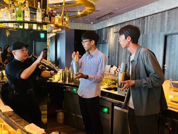青年學員在承億酒店體驗專業調酒技術，學習使用雪克杯的手法，以及服務顧客的流程。青年局提供
