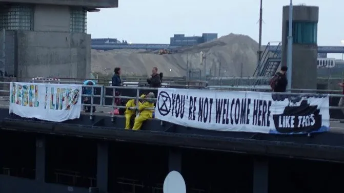 「反抗滅絕」環保人士在布條上寫著「為了生命，我們敢於反抗」(左）和「這裡不歡迎你（郵輪）」。翻攝自X@NLRebellion
