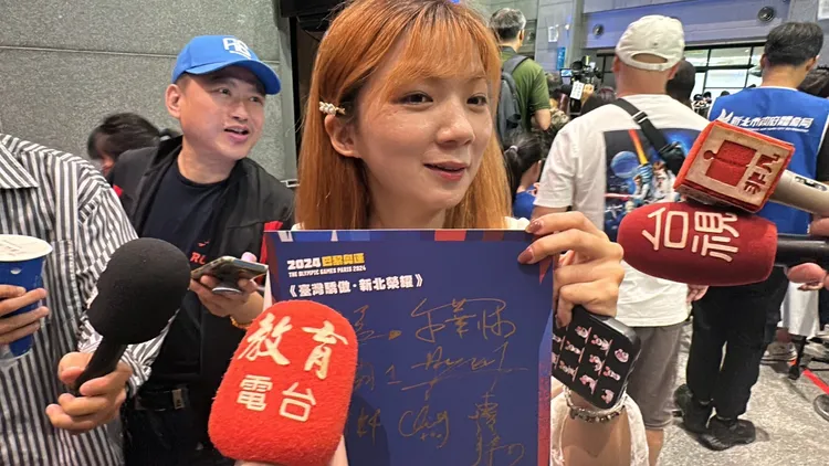 粉絲拿著比賽海報請林郁婷簽名，更拿手機與偶像自拍留念。曾佳俊攝