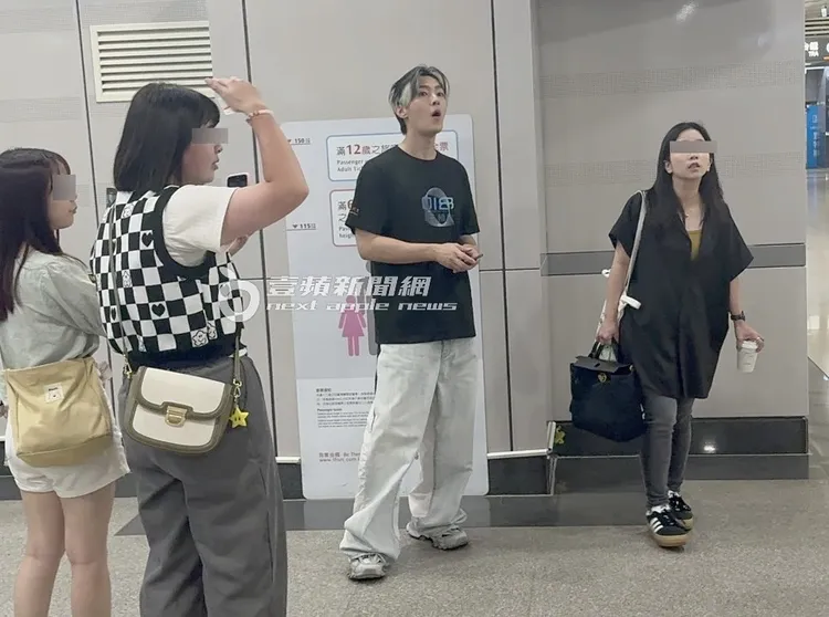 炎亞綸（中）站在高鐵南港站月台等車，鐵粉們依舊不離不棄跟在身旁。特勤中心攝