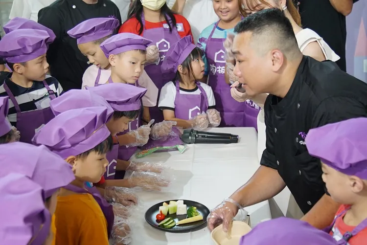 「陶板屋」前往苗栗山區小學舉辦職涯體驗營，主廚正向孩子們示範餐盤份量。業者提供