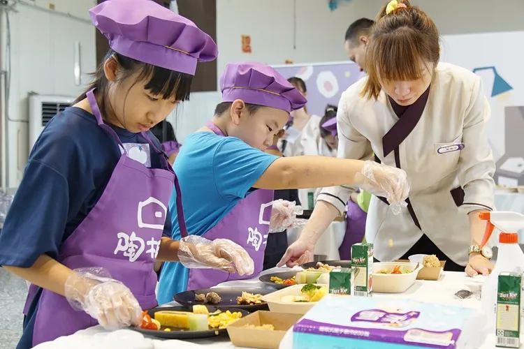 「陶板屋」前往苗栗山區小學舉辦職涯體驗營，孩子們正在動手裝盤。業者提供