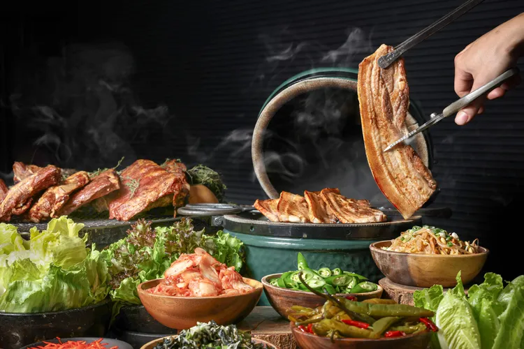 中秋大烤宴主打異國烤肉美饌，餐台上端出以大火直烤的現切豬五花搭配各式韓式佐料、小點。業者提供