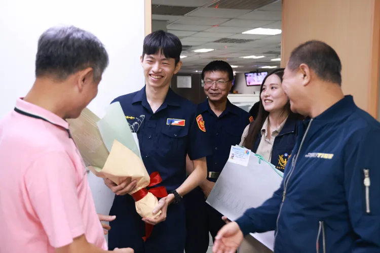 保安警察大隊警員吳旻哲(左二)向在警局上班的父親勤務指揮中心專員吳恒隆(左一)獻上祝福。警方提供