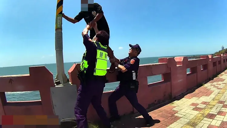 陳男在大橋護欄上搖搖欲墜，員警見機趕緊將他拉下。民眾提供