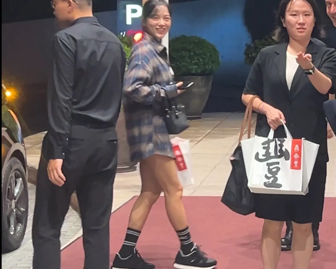 深夜近11点,金世正(中)返回下榻饭店,见到粉丝热情问候笑开怀。特勤中心摄