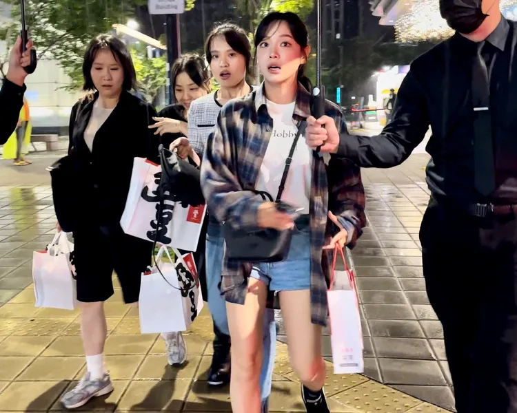 金世正（中）跟著韓國工作人員逛信義商圈，見到前方街頭藝人表演，露出驚訝表情。特勤中心攝