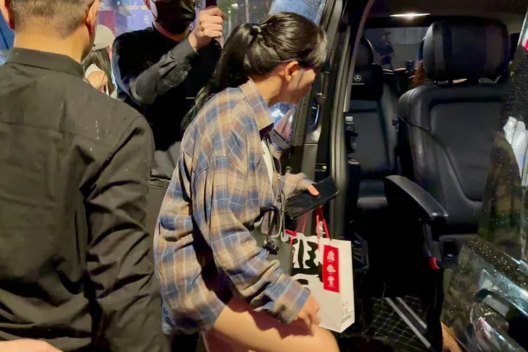 金世正手拿鼎泰豐伴手禮，坐上保母車。特勤中心攝