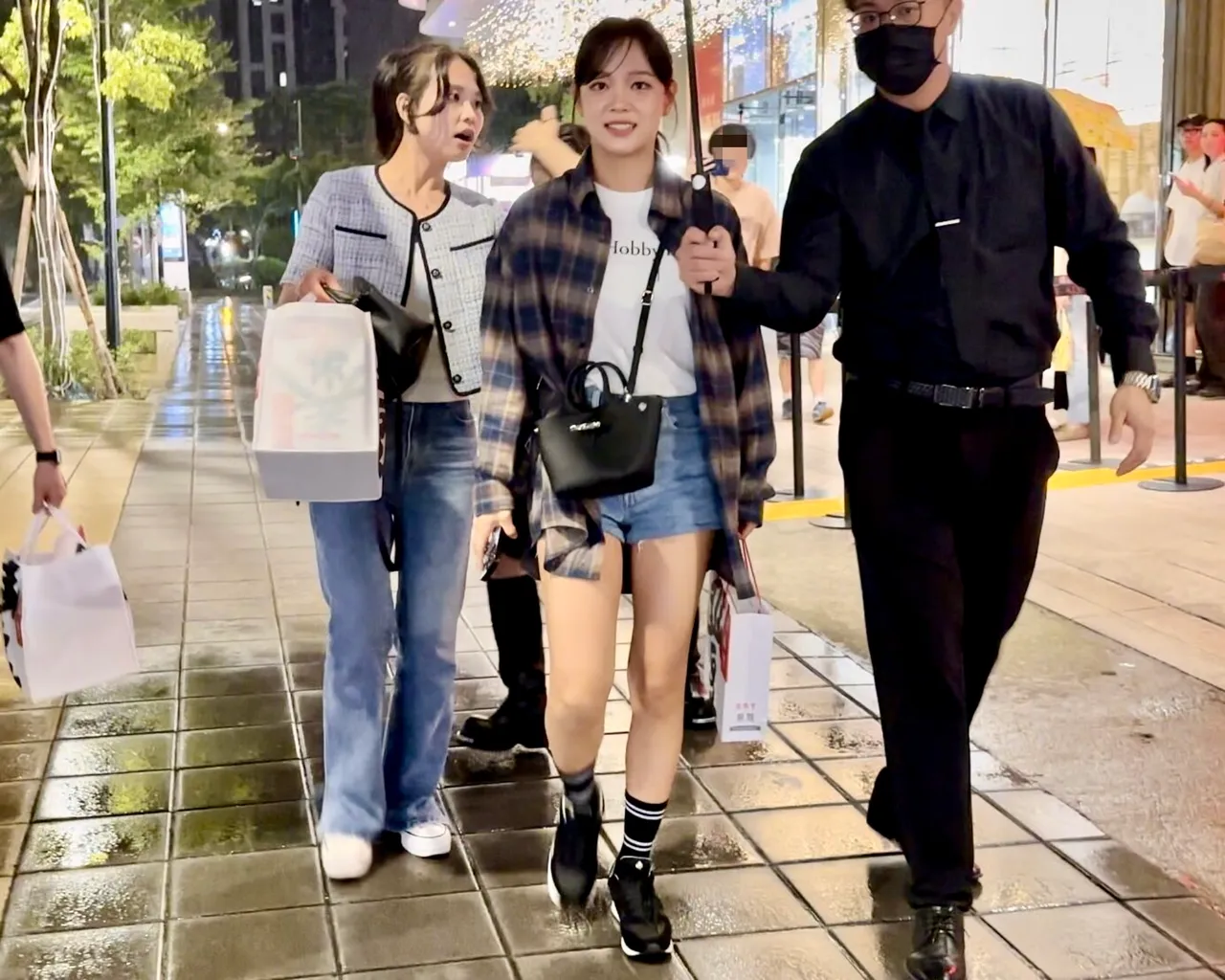 品尝完鼎泰丰小笼包,保母车司机帮忙金世正(中)撑雨伞。特勤中心摄