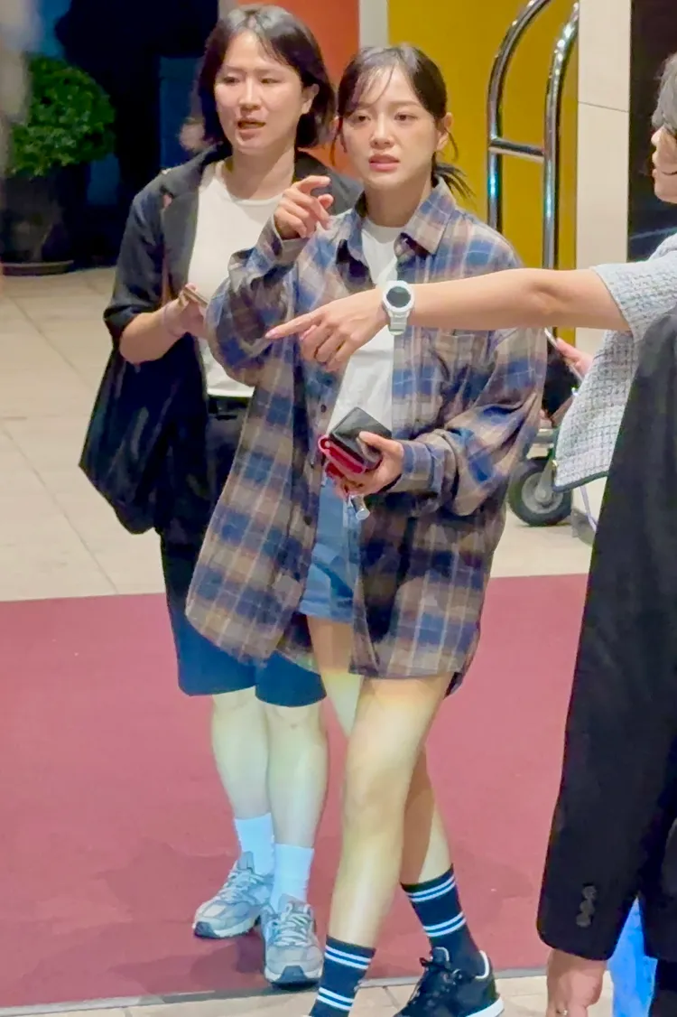 金世正拿著手機和錢包，往粉絲方向比去，想要上去簽名。特勤中心攝