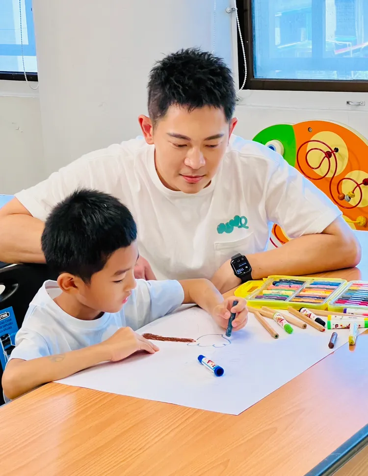 主播王顯瑜拍攝宣傳影片時，與腦麻兒開心互動。腦麻協會提供