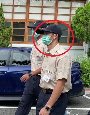 許光漢戴帽子、口罩低頭前進，態度低調。中央社