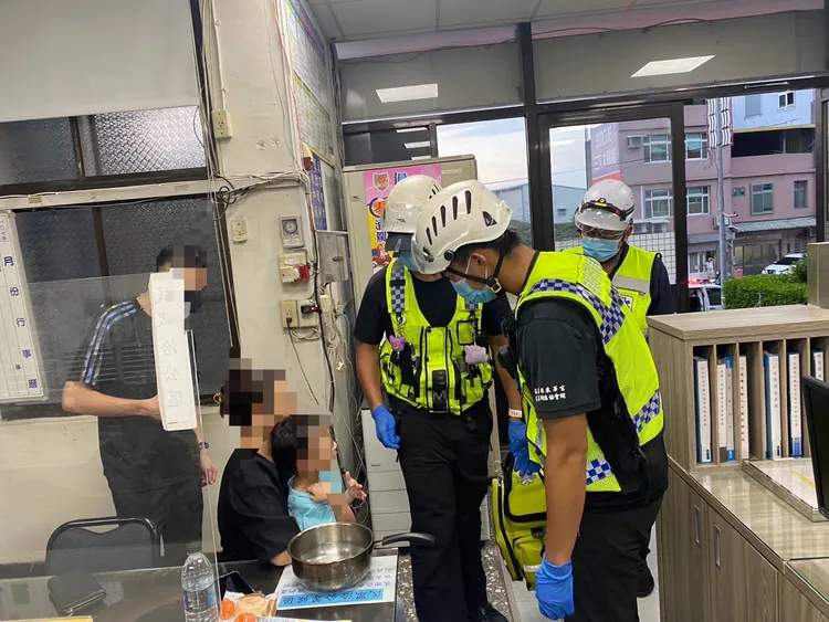 警方將吳姓少婦母子帶回派出所，她的丈夫急忙趕來安撫。民眾提供
