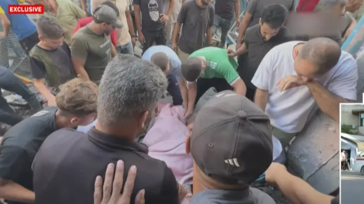 群眾將遇空襲死亡的遺體從廢墟中挖出，並用布綑起來搬到埋葬地點。翻攝自半島電視台