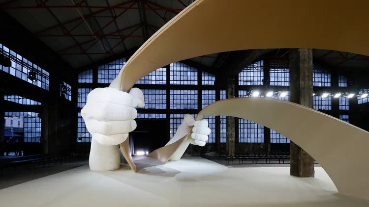 藝術家Lorenzo Quinn創作出兩隻手握著交錯的皮革帶的裝置藝術。品牌提供