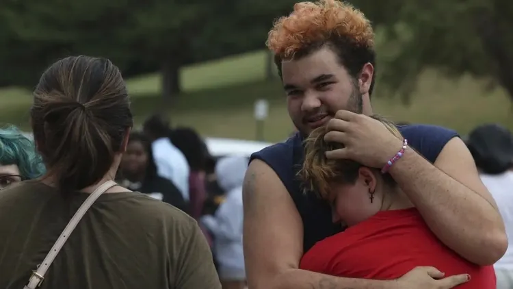 一名學生父親與孩子開心地在事發後擁抱。美聯社