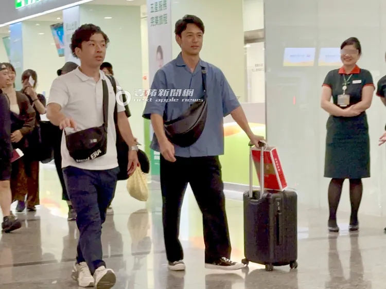 妻夫木聰推著登機箱準備上樓出境過海關。特勤中心攝