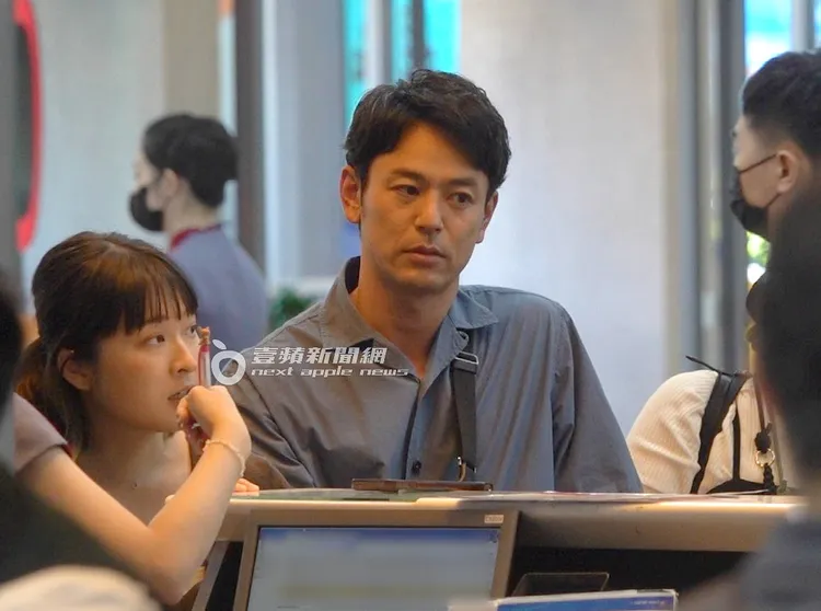 妻夫木聰走到華航櫃檯核對身分託運行李。特勤中心攝