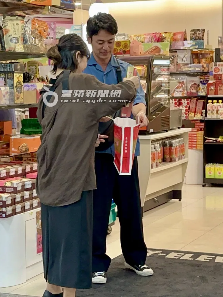 妻夫木聰滿足看著助理將鳳梨酥禮盒放入袋子。特勤中心攝