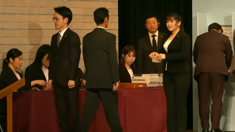 被網友形容為巨乳的女工作人員，在投票過程中負責遞交選票。翻攝自自民黨YouTube