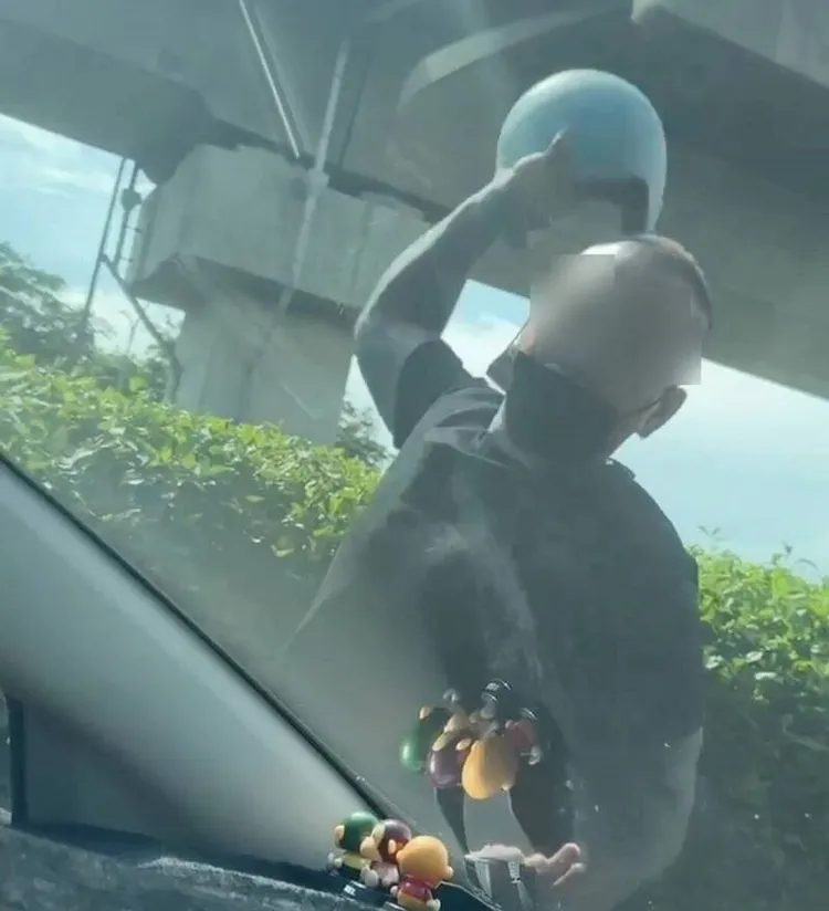 倒數後他隨即脫下安全帽，對著擋風玻璃暴打。翻攝照片