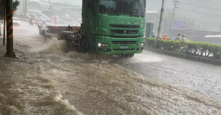 車輛經過將大量泥水捲上人行道。葉先鵬攝