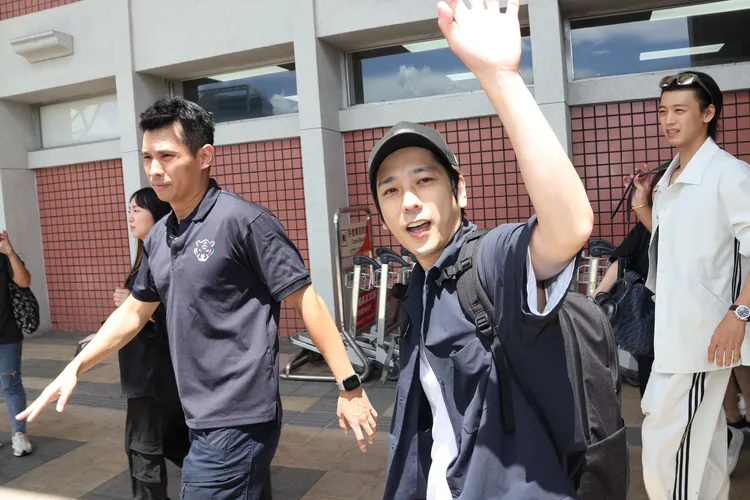 二宮和也走出機場，踏上保母車前揮手示意。莊宗達攝