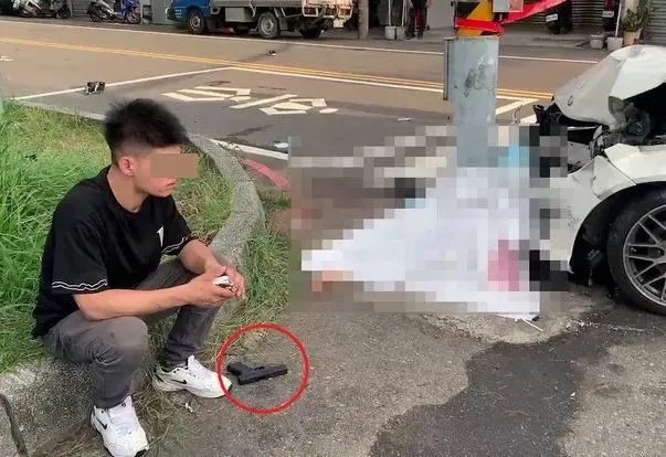 肇事者呆坐路旁，腳邊還有從車上搜出的道具槍。警方提供