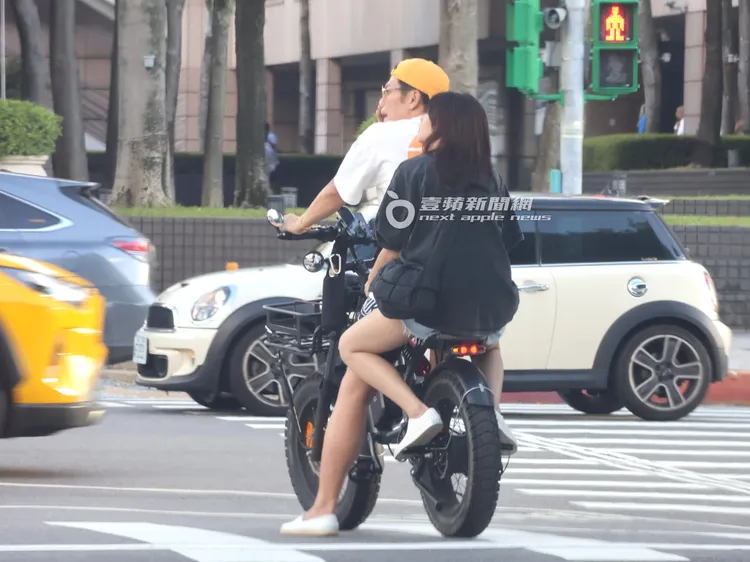 夫妻倆騎乘電動自行車穿梭在台北街頭。特勤中心攝