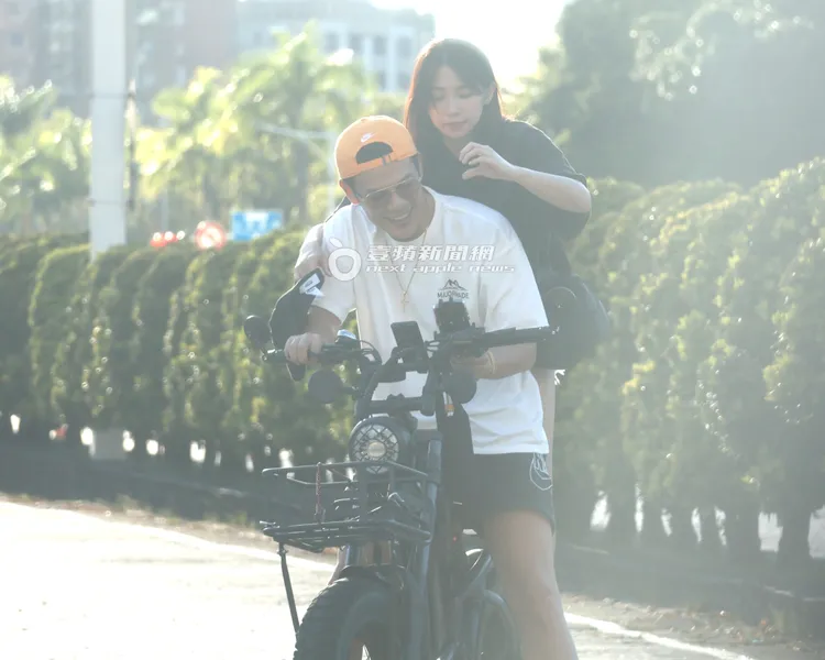 曾智希手比愛心手勢，等待陳志強將愛心的另外一半填滿，畫面充滿粉紅泡泡。特勤中心攝