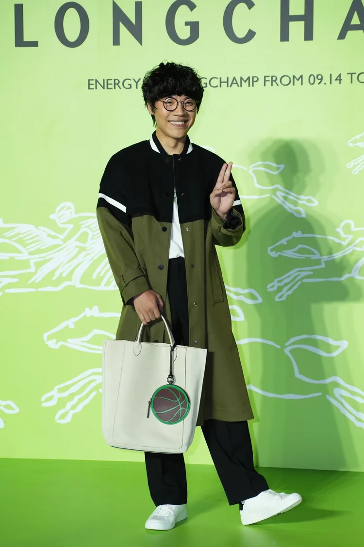 盧廣仲配戴的亞麻色Cabas Longchamp手提包還掛上籃球零錢包。彭欣偉攝