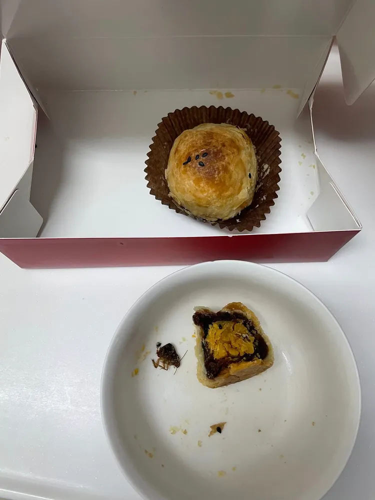 爆料人在臉書社團貼出蛋黃酥及半截蟑螂，卻對業者說不確定能否提供化驗。翻攝「爆料公社二社」