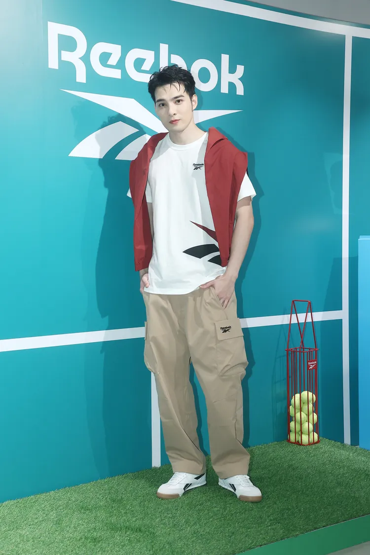 黃偉晉穿著白色短T、卡其長褲，並肩披紅色開襟點綴視覺。攝影中心攝
