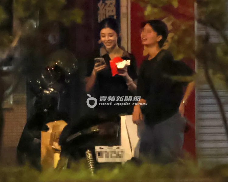 深夜12點，詹子萱（左）結束2個多小時拍攝工作，拿著麥當勞薯條跟雞塊站在路邊滑手機。特勤中心攝