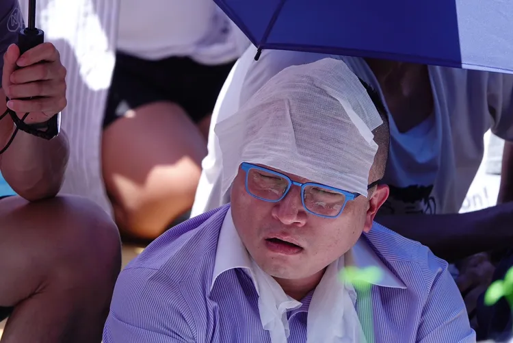 民眾黨秘書長周榆修也似乎熱到昏頭，用紙巾蓋著額頭舒緩。記者莊宗達攝