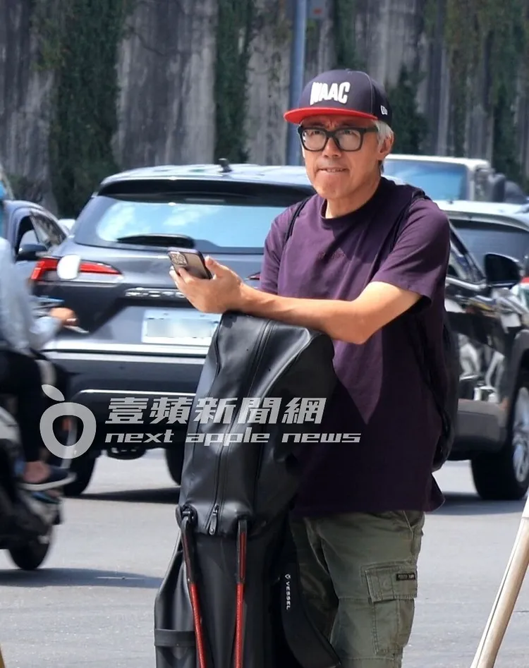 張宇將手撐在球具上，站在路邊等車。特勤中心攝