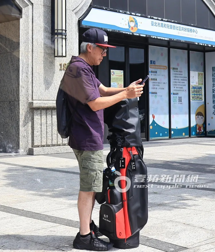 張宇滑著手機等待多元化計程車抵達。特勤中心攝