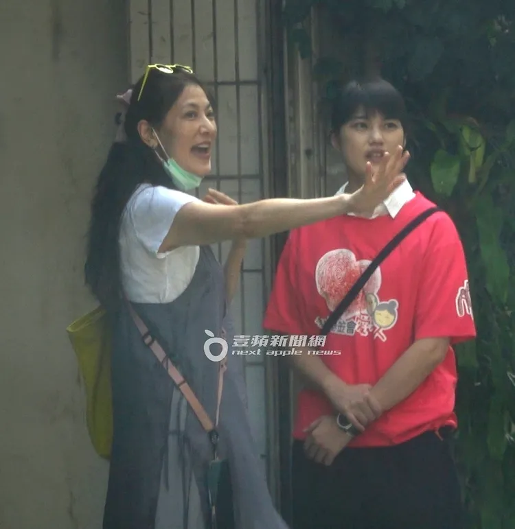 丁柔安（左）拉下口罩向路過的工作人員揮手道別。特勤中心攝