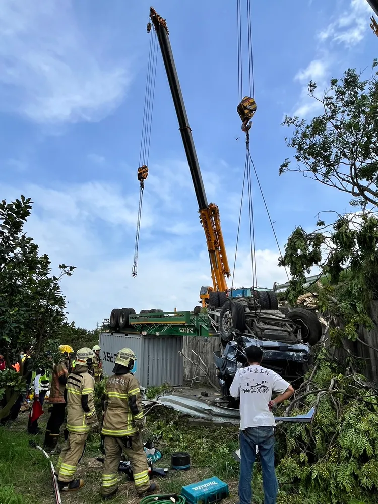 消防人員請來大型吊車支援，把車頭吊起才能破壞車頭協助司機脫困。民眾提供