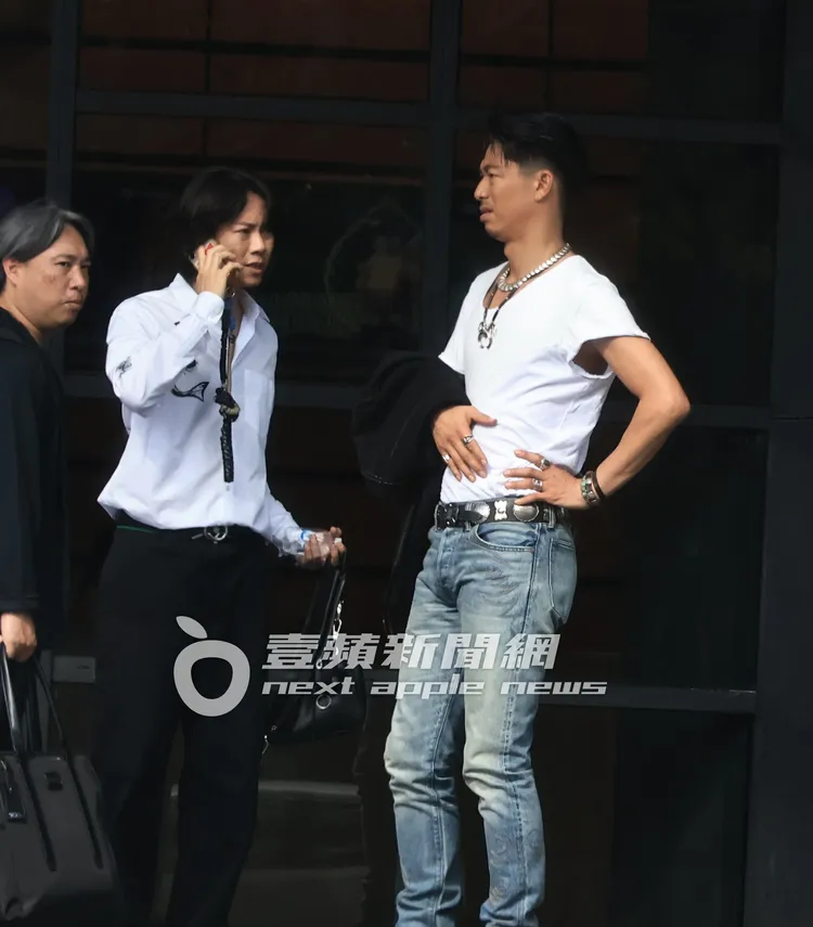 AKIRA插著腰，一手摸著肚子看助理聯絡保母車。特勤中心攝