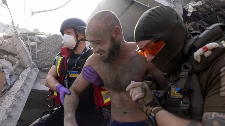 哈爾科夫購物商場附近一名民眾在襲擊下受傷，遭救難人員救出。路透社