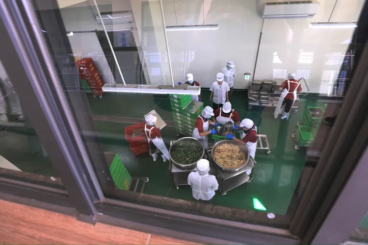 學生可以透過參觀廊道觀察午餐製作的過程。市府提供