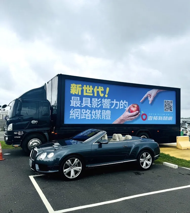 《壹蘋》廣告專用卡車旁邊停了一台拉風的賓利敞蓬車。