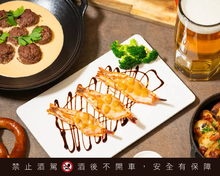 鐵板現煎的「德式黑啤酒煎鮮蝦」，黑啤酒的香氣與彈嫩蝦肉完美融合，口感令人難忘。業者提供