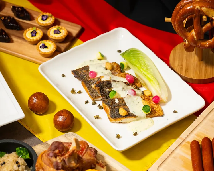 以白酒提香的「德式芥末籽茴香鱸魚」，襯托鱸魚鮮嫩肉質與草本香氣，風味層次豐富。業者提供