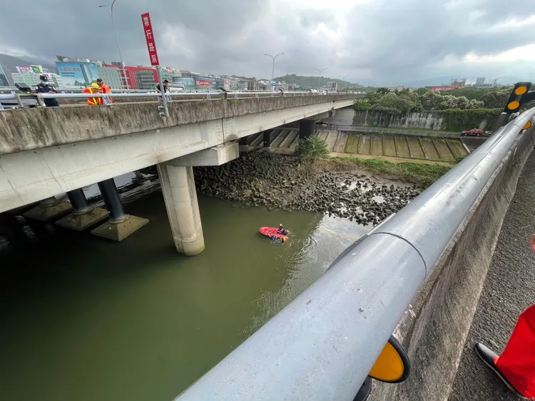 國1汐五高架道堤頂段，小客車衝出6層樓高護欄墜入基隆河。