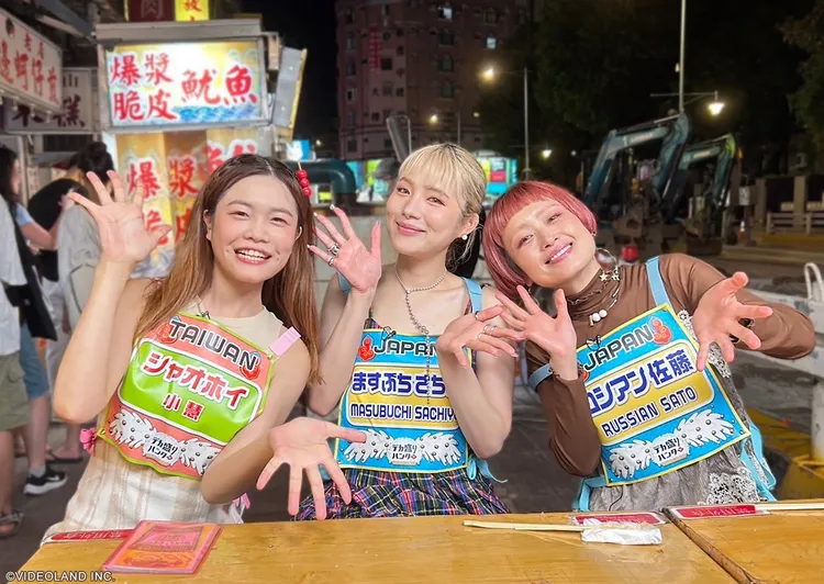 小慧（左）盡地主之誼，親自排隊採買寧夏夜市人氣小吃，熱情餵食大胃女王前輩俄羅斯佐藤。緯來綜合台提供