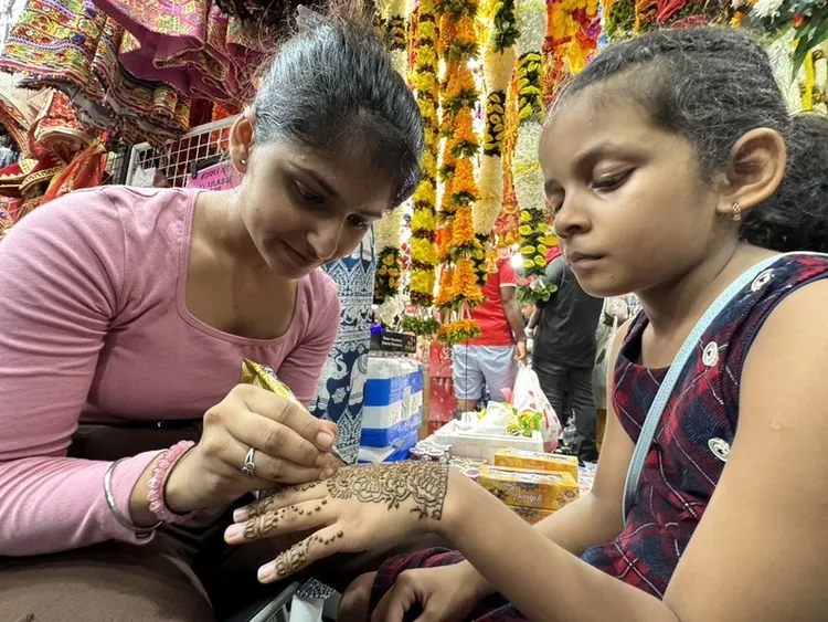 新加坡印度社群民族節慶屠妖節登場，小印度街頭充滿五顏六色的燈飾與飾品。圖為一名印度裔女孩正在進行手部繪畫。 中央社