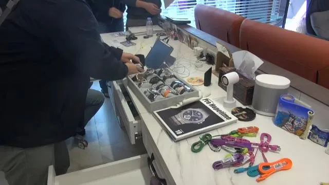 台中警方搜索水房據點，查扣大批現金與名錶等奢侈品。翻攝照片